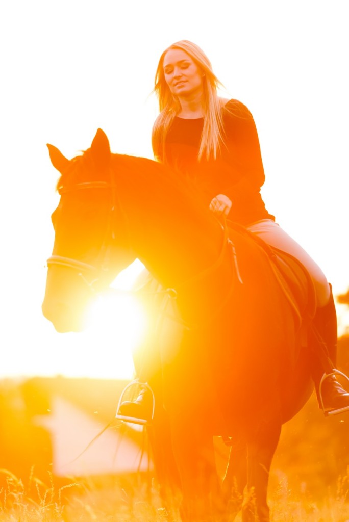 Junge hübsche Frau genießt Ihre Freizeit an einem wunderschönen Sommerabend mit Ihrem Pferd.