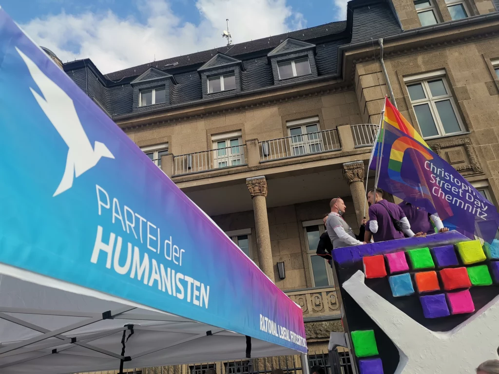 Pavillion der Partei der Humanisten und Menschen mit Flagge Christopher Street Day Chemnitz auf einem Fahrzeug beim CSD Düsseldorf 2021