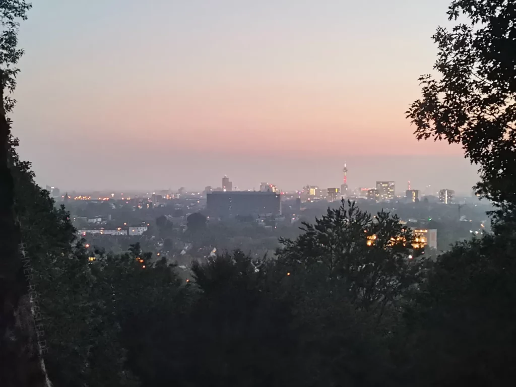 Sonnenuntergang über Düsseldorf. Die Lichter der Gebäude sind an.