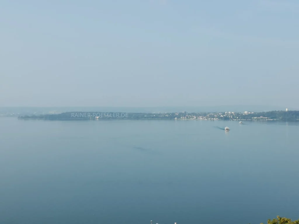 Landschaft mit Wasser. 2 Wasserfahrzeuge am Fahren. Leichter Nebel.