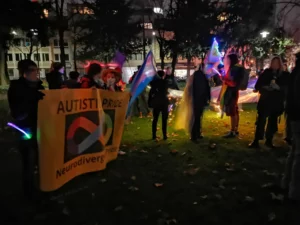 Im dunkeln halten Menschen auf einer grünen Wiese einen Banner in der Hand mit der Aufschrift 