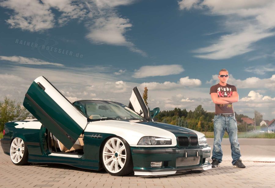 Hübscher Mann steht neben seinem edel-getunten BMW Automobil. Beim Fotoshooting mit Fotograf Rainer Rössler