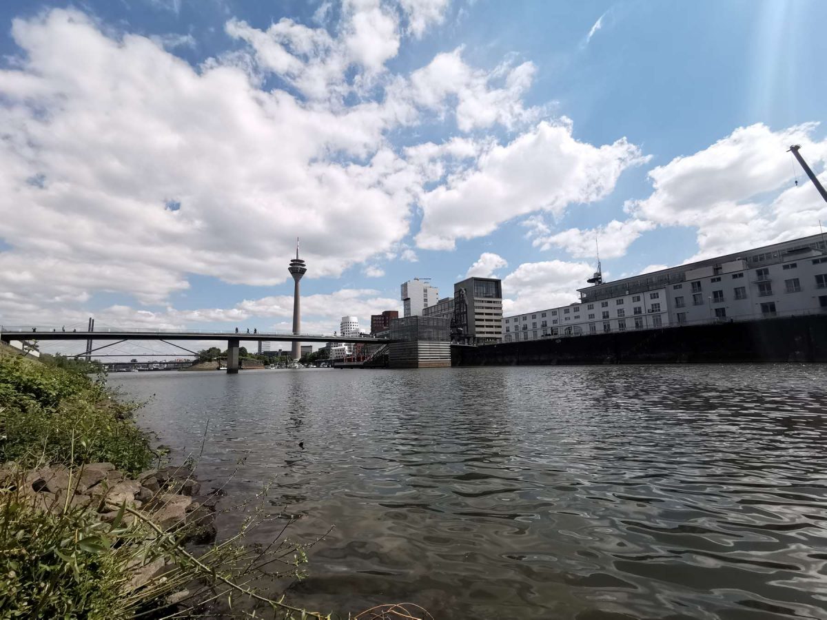 Wie Yin und Yan - der fließende Rhein schlängelt sich durch die massiven, designstarken Bauten im Medienhafen Düsseldorf