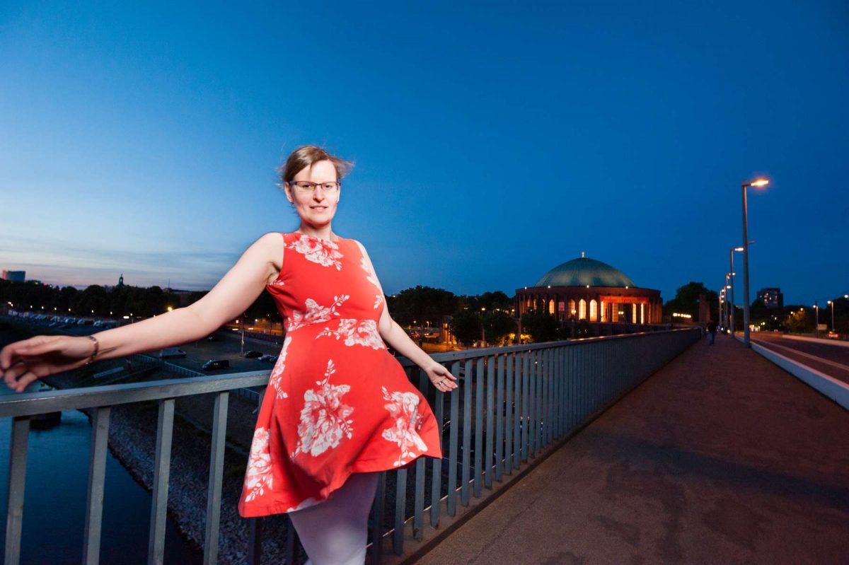 Foto von einer hübschen Frau in ihrem roten Kleid in Düsseldorf. Fotografiert von Fotograf Rainer Rössler