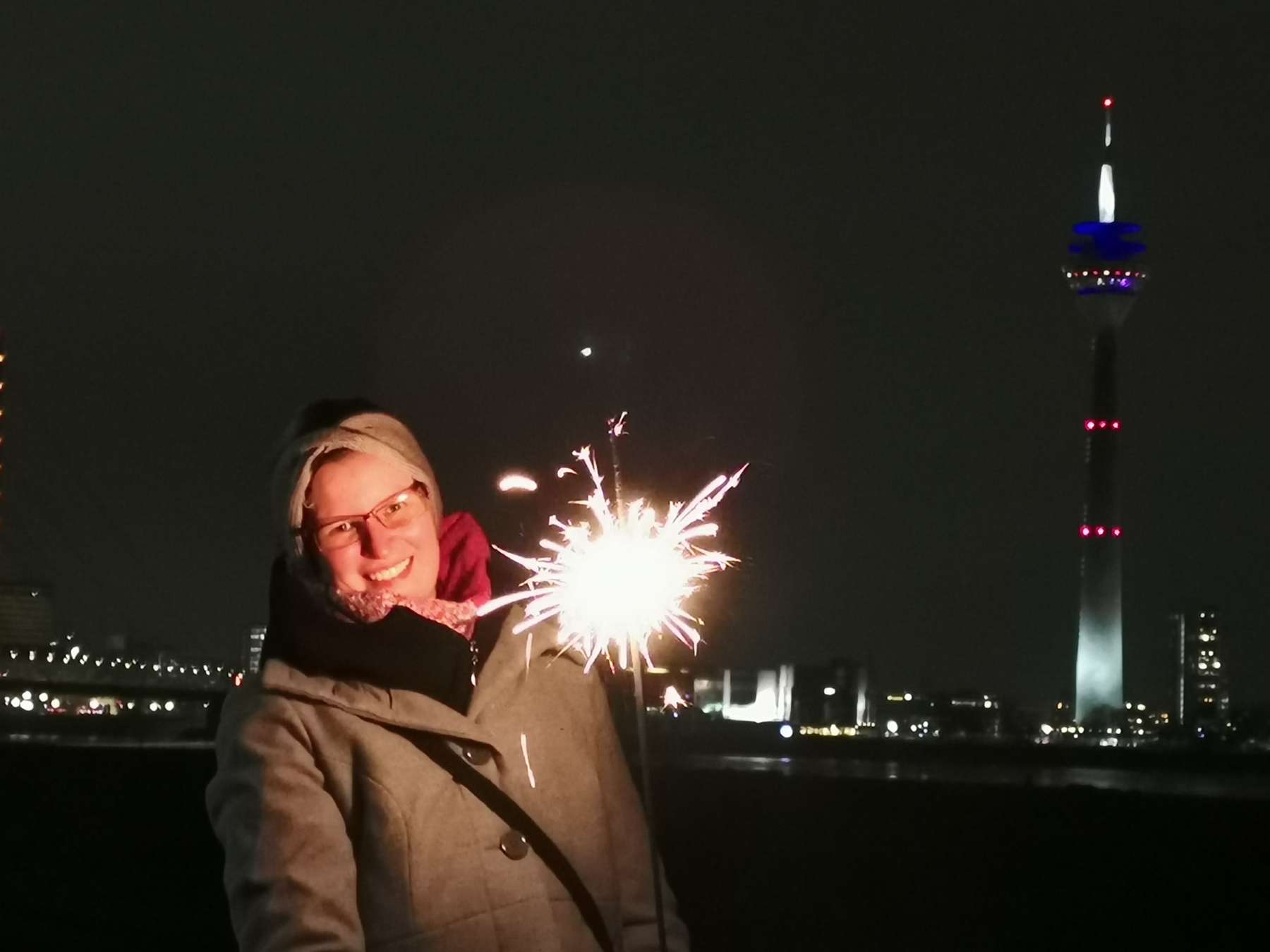 Portrait-Shooting vor den Stadtlichtern der Düsseldorfer Skyline mit besonderem Licht einer Wunderkerze