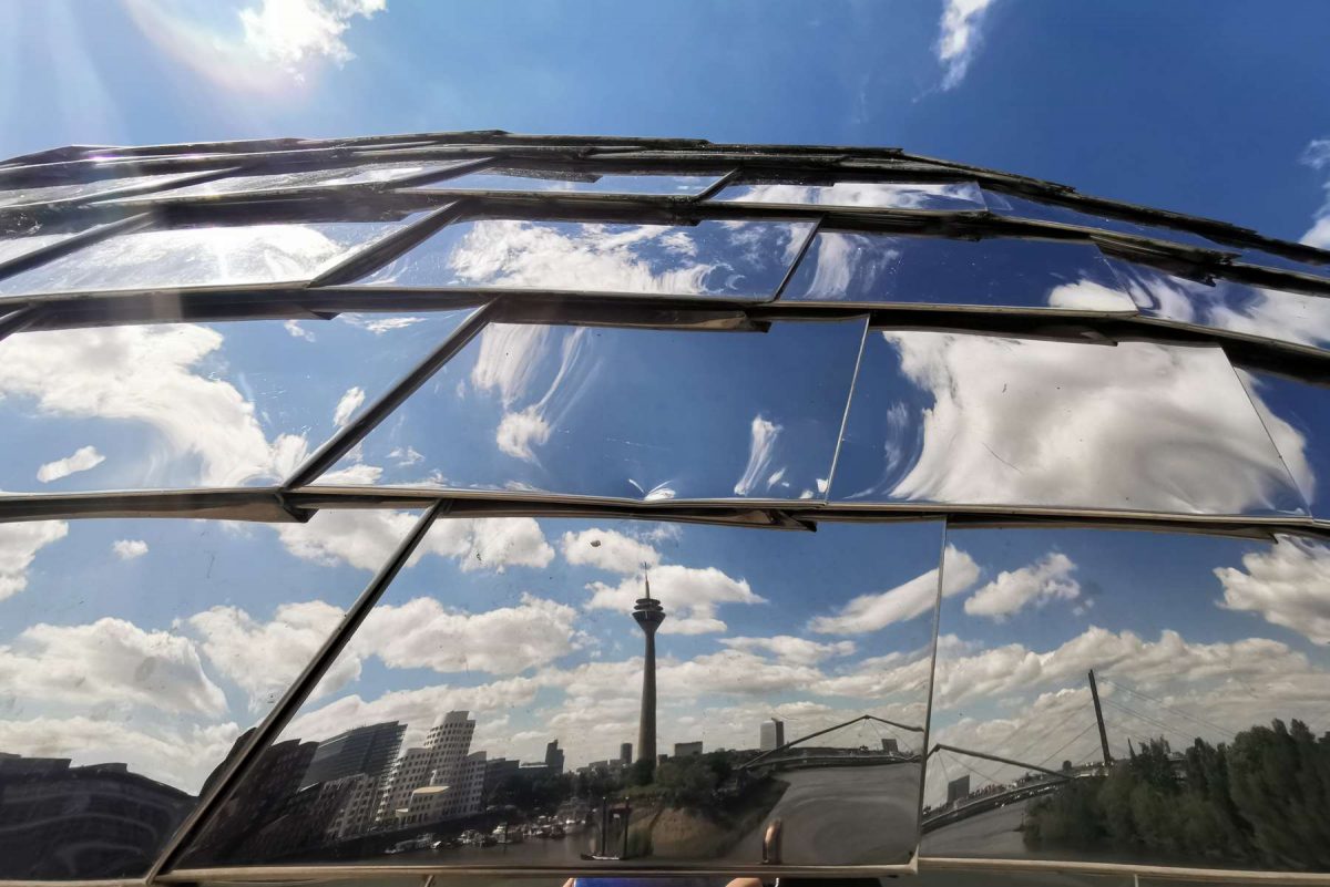 Perspektivenwechsel - der Düsseldorfer Medienhafen erstrahlt in der Glasfassade des ikonischen Pebbles