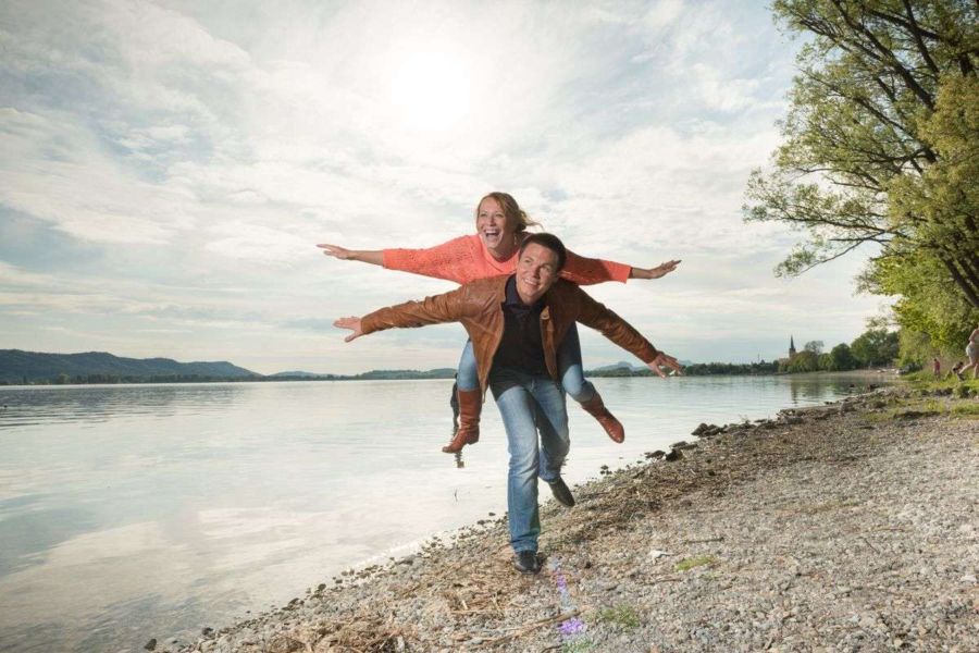 Foto von einem verlobten Pärchen beim Engagement-Shooting fotografiert von Fotograf Rainer Rössler auf der Halbinsel Mettnau in Radolfzell am Bodensee Lebensfrohes Engagement-Shooting am Bodenseeufer