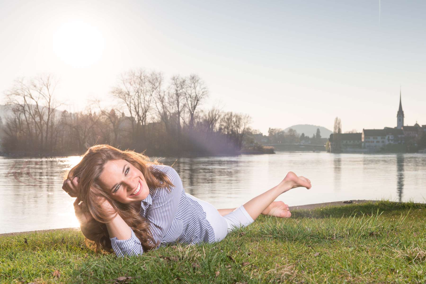 Hübsche Frau liegt am Rhein in Stein am Rhein (Schweiz) auf einer Wiese und genießt das Fotoshooting mit Fotograf Rainer Rössler
